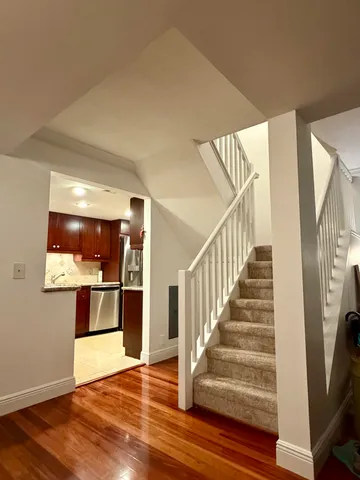 a living room with furniture large window and wooden floor
