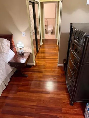 a bedroom with a bed and wooden floor