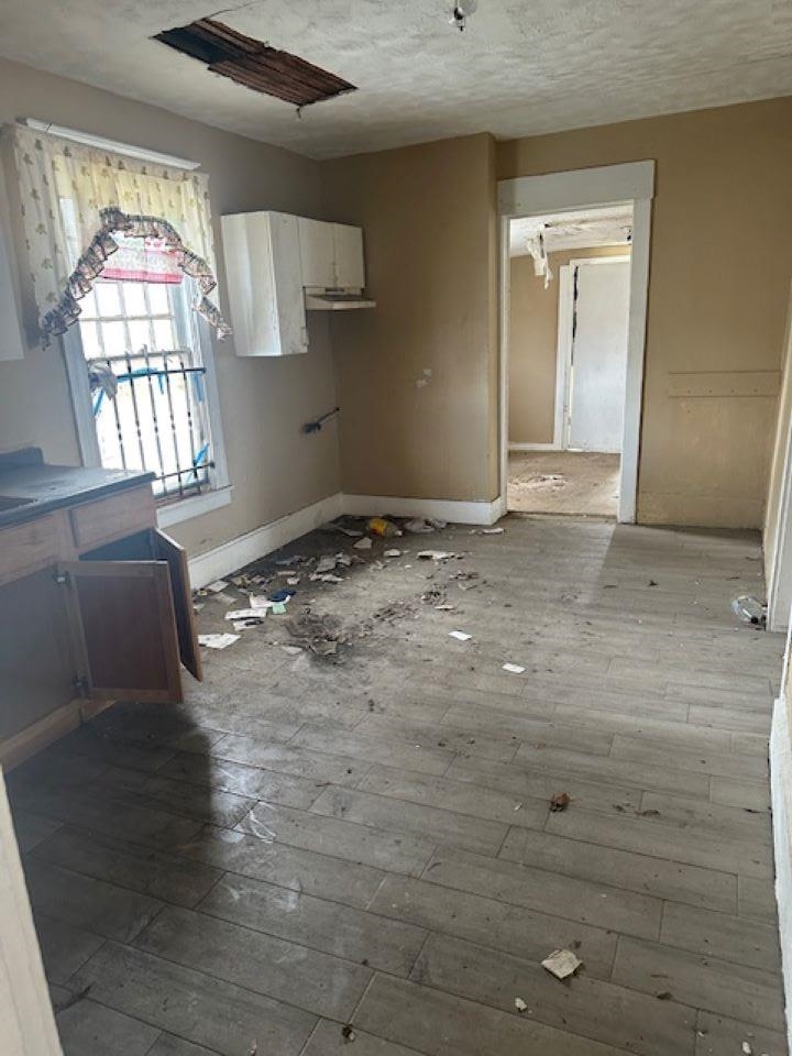 942 Roland Street, Unit 3 Memphis, TN 38114 - Photo 11 of 13 Kitchen with dark wood-style floors, a textured ceiling, and white cabinets