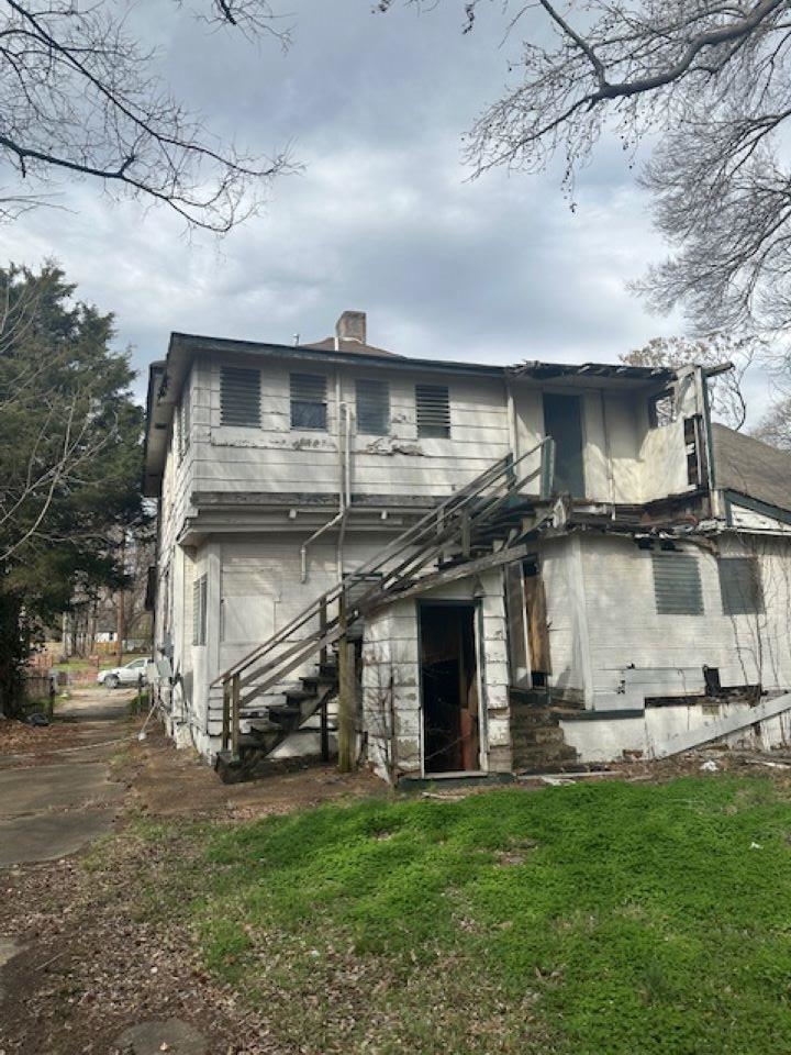 942 Roland Street, Unit 3 Memphis, TN 38114 - Photo 3 of 13 Rear view of property featuring a chimney, a lawn, and a balcony