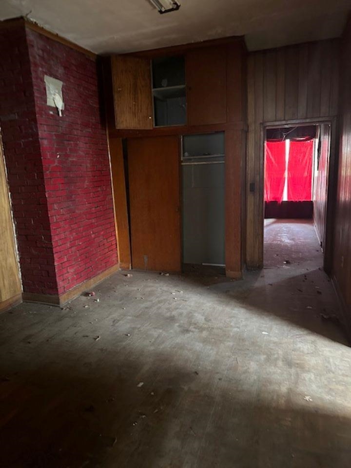 942 Roland Street, Unit 3 Memphis, TN 38114 - Photo 8 of 13 Unfurnished bedroom featuring wooden walls and a closet