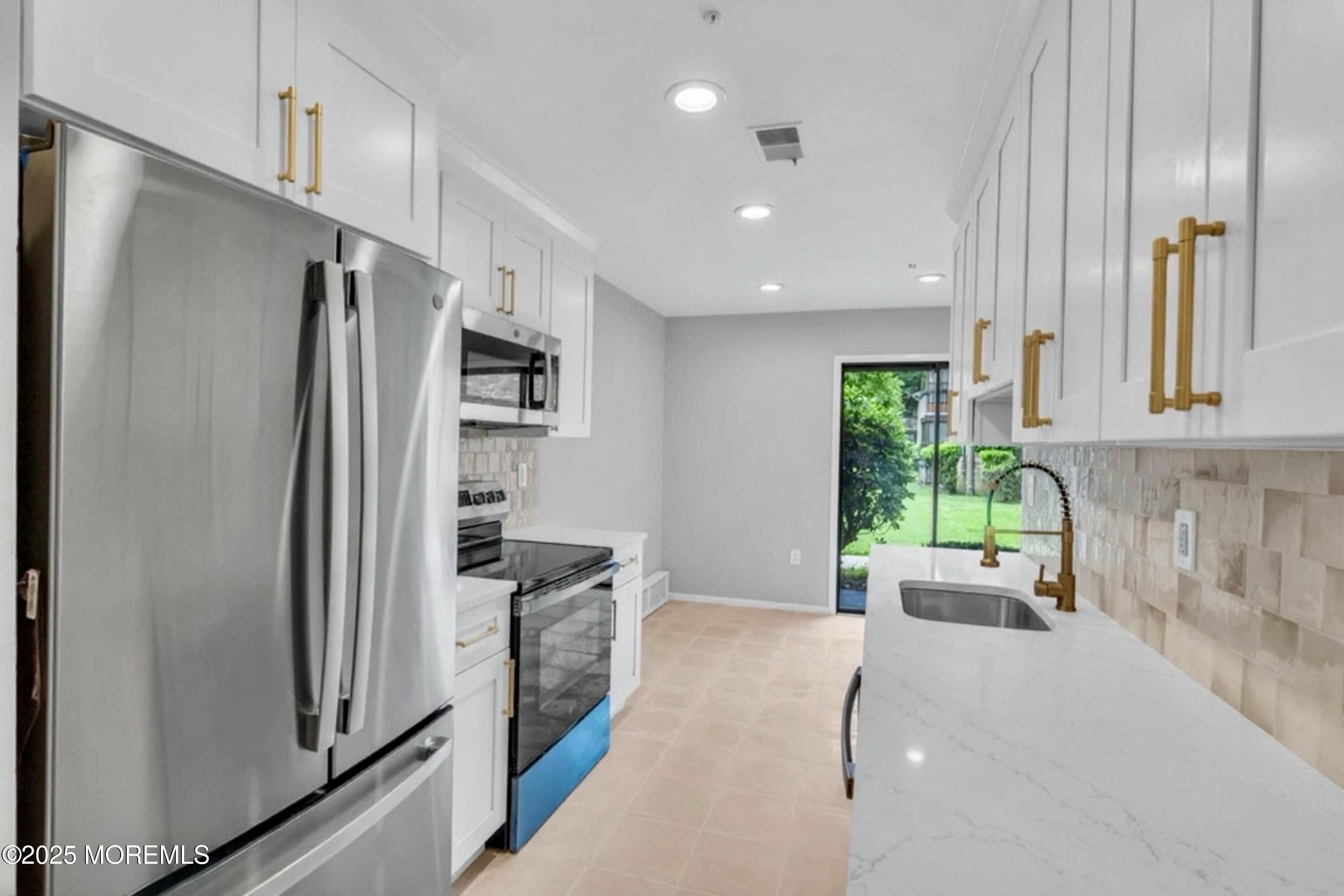a kitchen with stainless steel appliances granite countertop a refrigerator and a stove