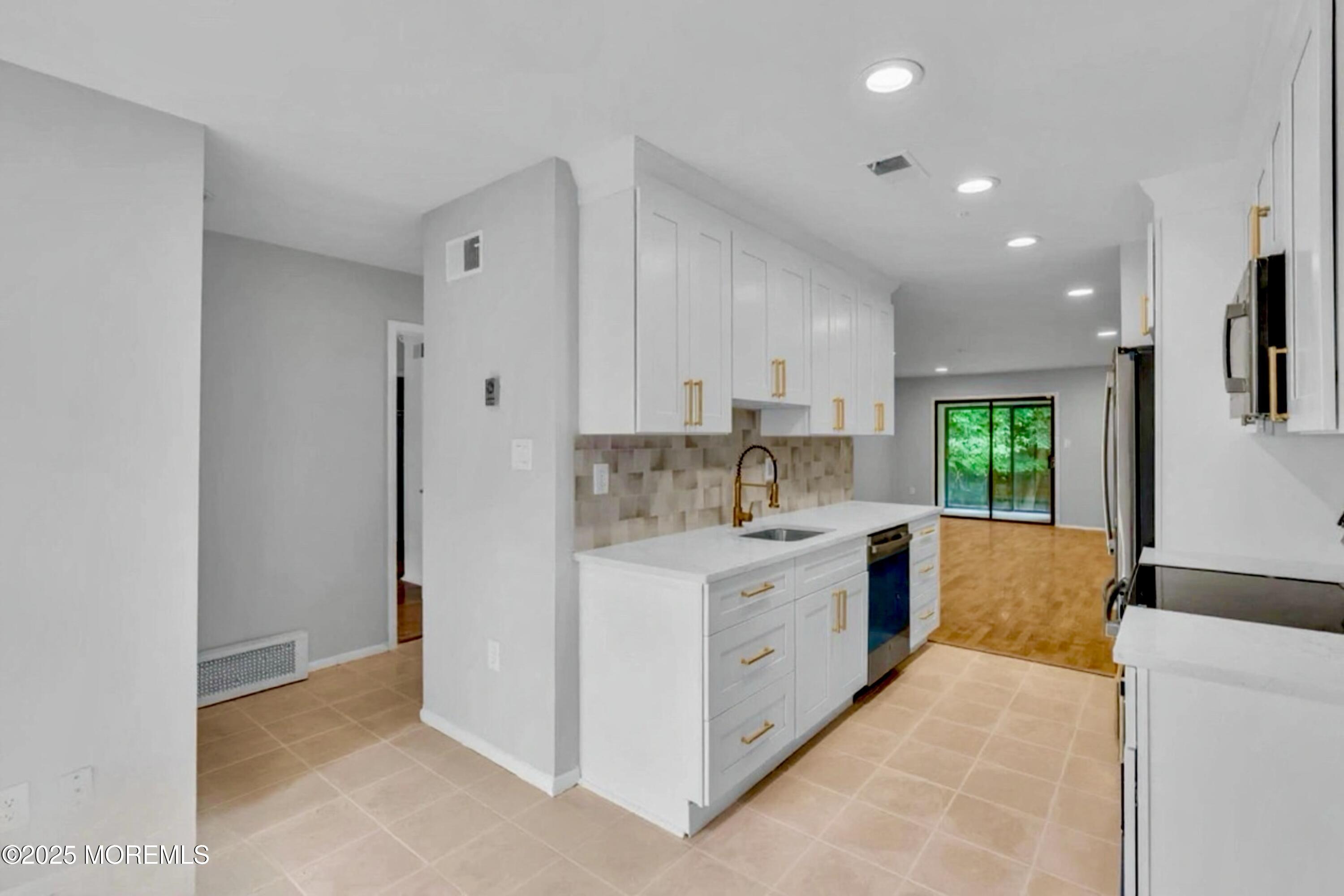 70 Overlook Way, Unit A Manalapan, NJ 07726 - Photo 2 of 13 a large white kitchen with a sink and dishwasher a refrigerator with white cabinets