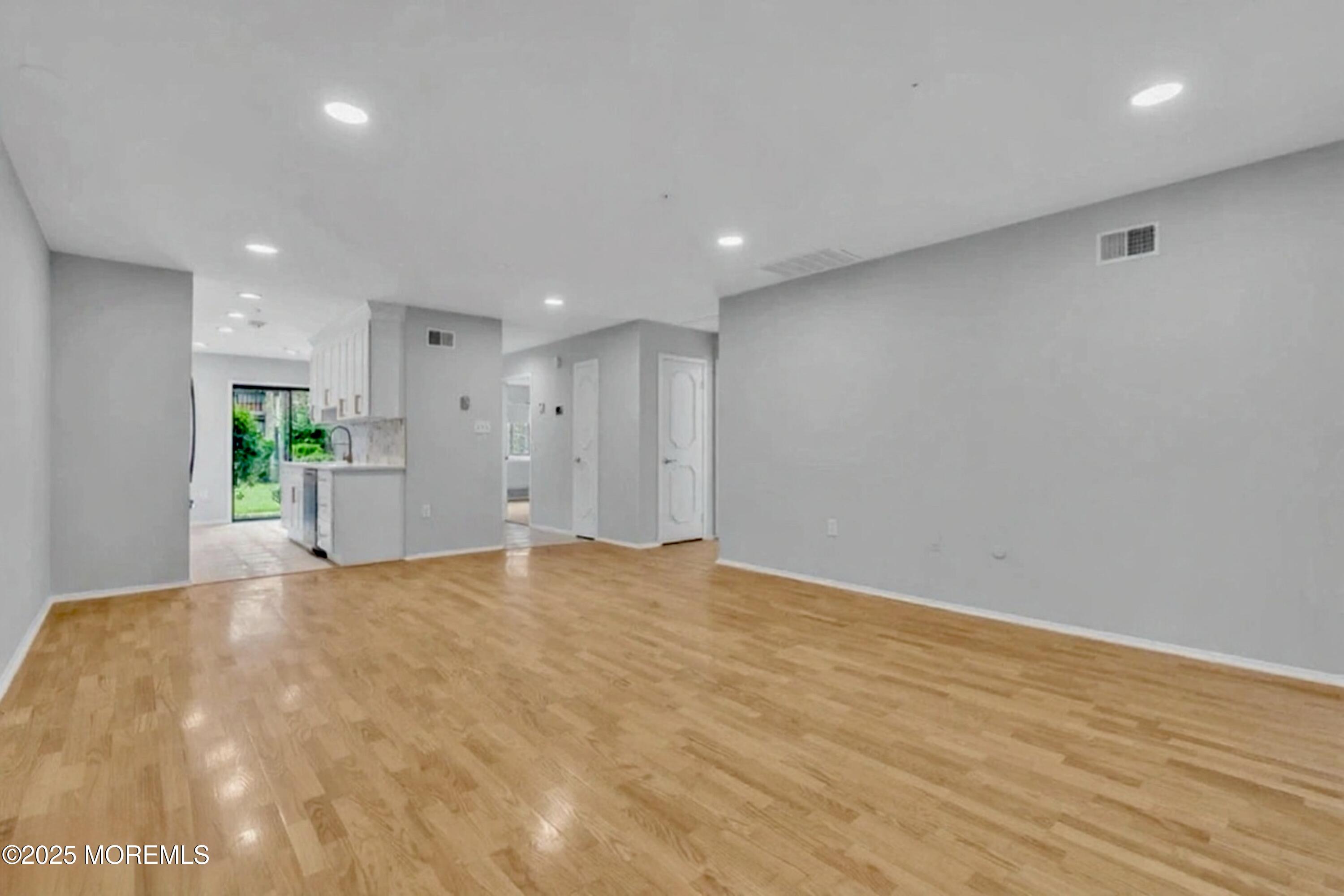 70 Overlook Way, Unit A Manalapan, NJ 07726 - Photo 5 of 13 a view of an empty room with wooden floor and a window