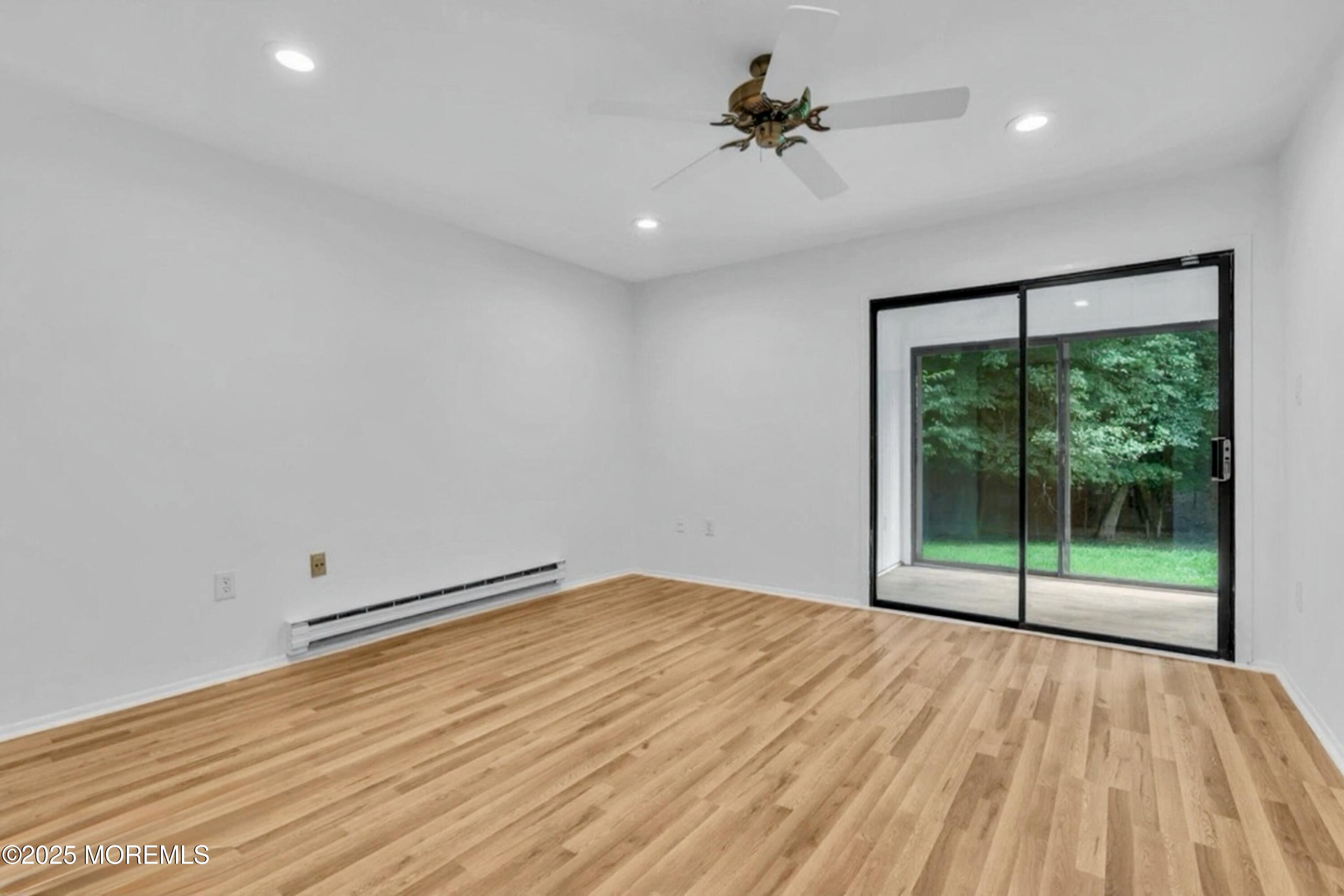 70 Overlook Way, Unit A Manalapan, NJ 07726 - Photo 8 of 13 a view of empty room with wooden floor and fan