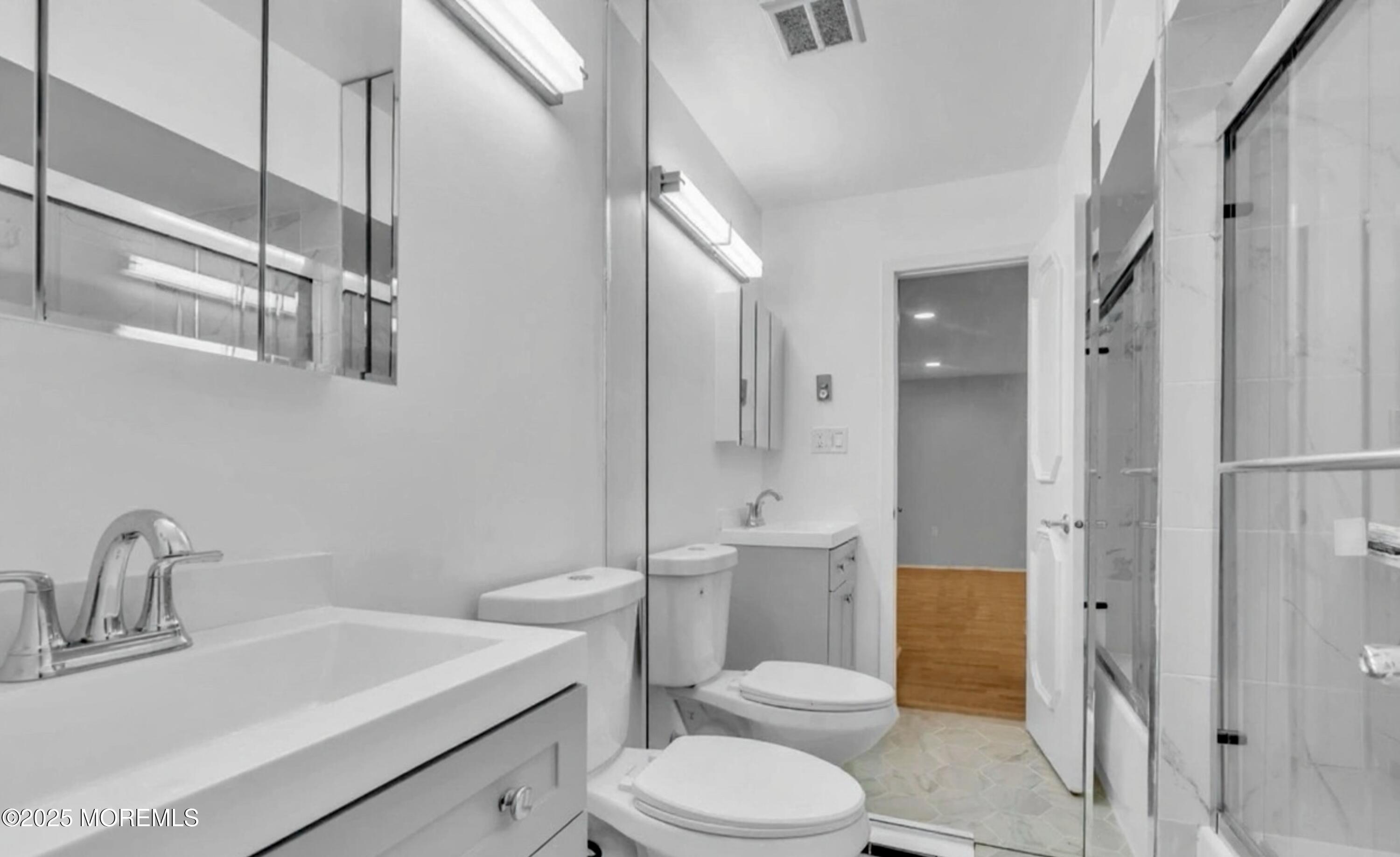 70 Overlook Way, Unit A Manalapan, NJ 07726 - Photo 9 of 13 a white toilet sitting next to a bathroom sink