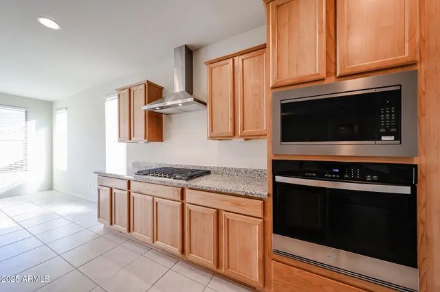 a kitchen with granite countertop cabinets stainless steel appliances and a window