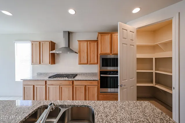 a kitchen with stainless steel appliances granite countertop a refrigerator and a sink