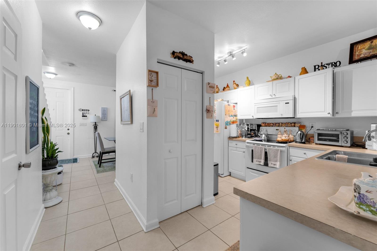 1595 Northeast 33rd Road, Unit 1123 Homestead, FL 33033 - Photo 12 of 34 a kitchen with stainless steel appliances a refrigerator sink and cabinets