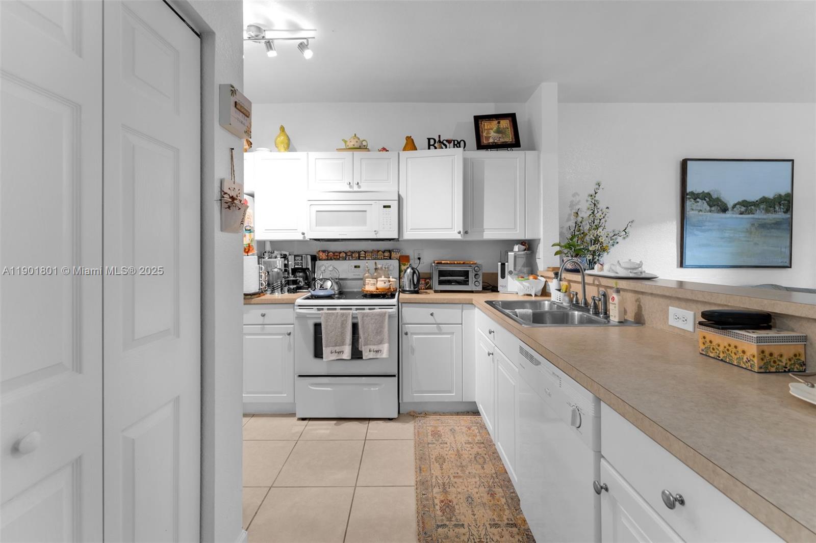 1595 Northeast 33rd Road, Unit 1123 Homestead, FL 33033 - Photo 7 of 34 a kitchen with cabinets and window