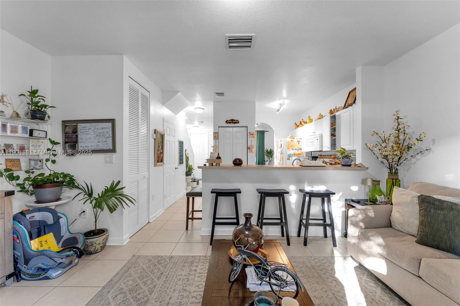 1595 Northeast 33rd Road, Unit 1123 Homestead, FL 33033 - Photo 10 of 34 a living room with furniture kitchen view and a potted plant