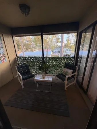 a living room with furniture and a dining table with bookshelf