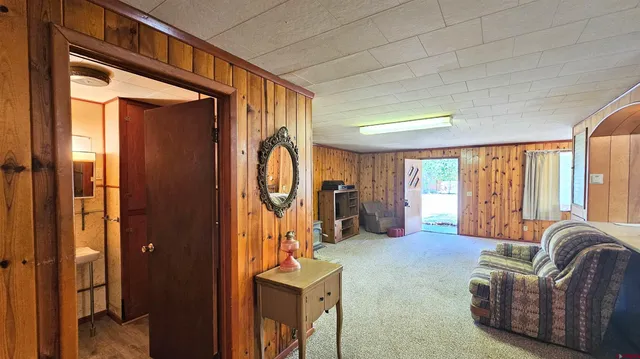 a living room with furniture a large window and chandelier