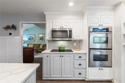 a kitchen with white cabinets and stainless steel appliances