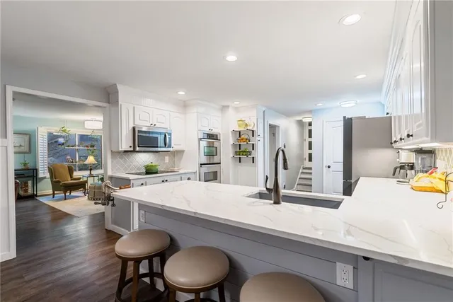 a kitchen with a refrigerator and white cabinets