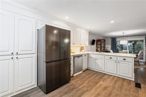 a bedroom with a bed a dresser and a flat screen tv