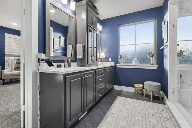 a en suite bathroom with a double vanity sink a mirror and a