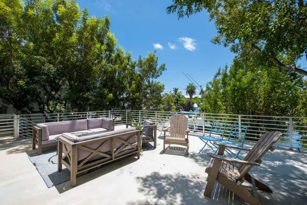 a view of a yard with table and chairs and potted plants