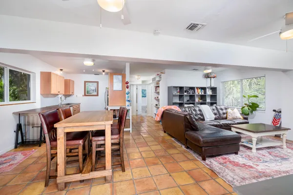 a kitchen with stainless steel appliances granite countertop a stove top oven a sink dishwasher and a refrigerator with wooden cabinets