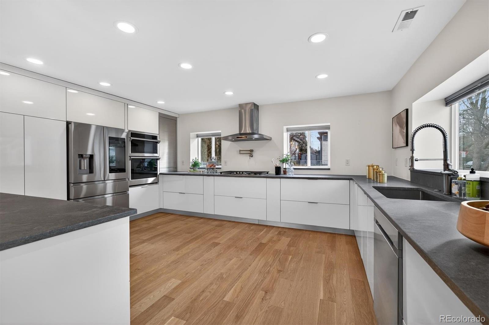 765 Kearney Street Denver, CO 80220 - Photo 11 of 35 a large kitchen with stainless steel appliances granite countertop a lot of counter space and wooden floors