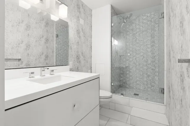 a bathroom with a bathtub shower sink vanity and toilet