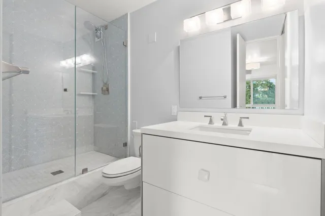 a bathroom with a granite countertop sink toilet and shower