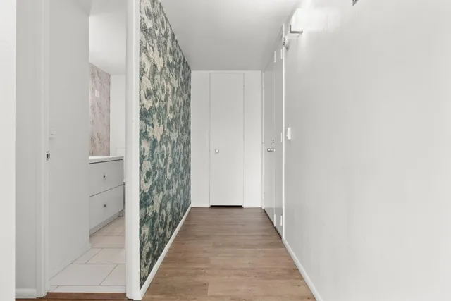a view of a hallway with wooden floor and a window