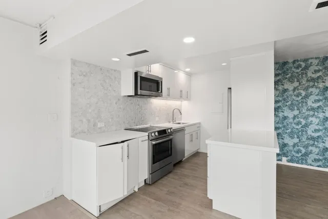 a kitchen with stainless steel appliances granite countertop a sink and a stove
