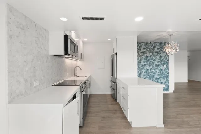 a kitchen with a sink a stove and a refrigerator