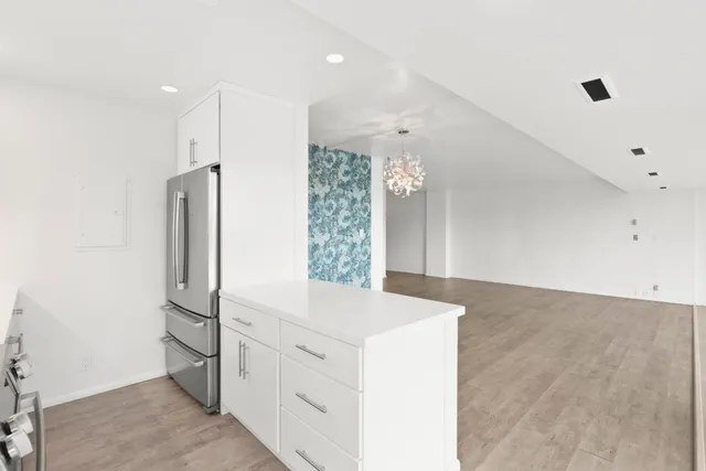 a kitchen with white cabinets and refrigerator