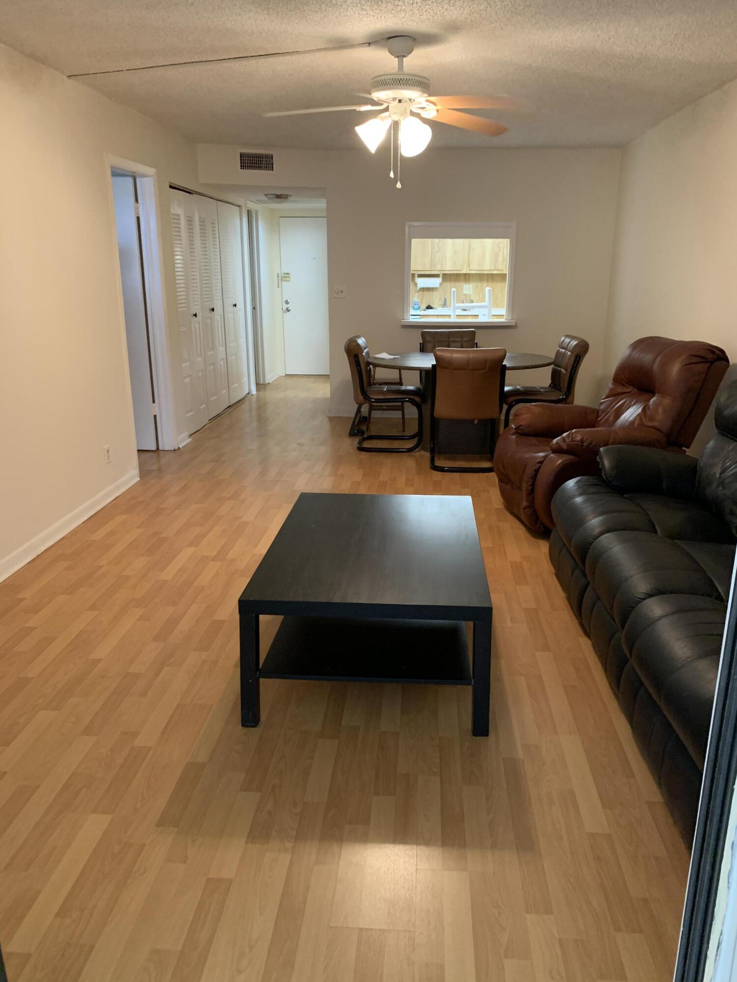 9273 Southwest 8th Street, Unit 416 Boca Raton, FL 33428 - Photo 5 of 14 a living room with furniture and a large window