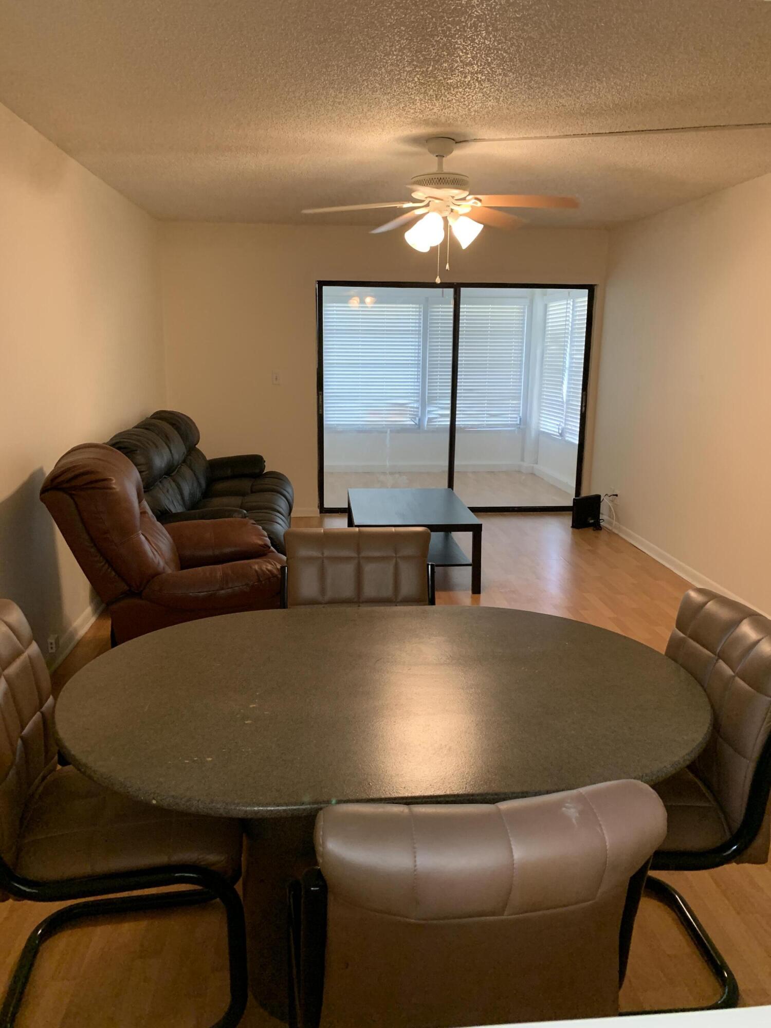 9273 Southwest 8th Street, Unit 416 Boca Raton, FL 33428 - Photo 6 of 14 a projector room with a table chairs and projector