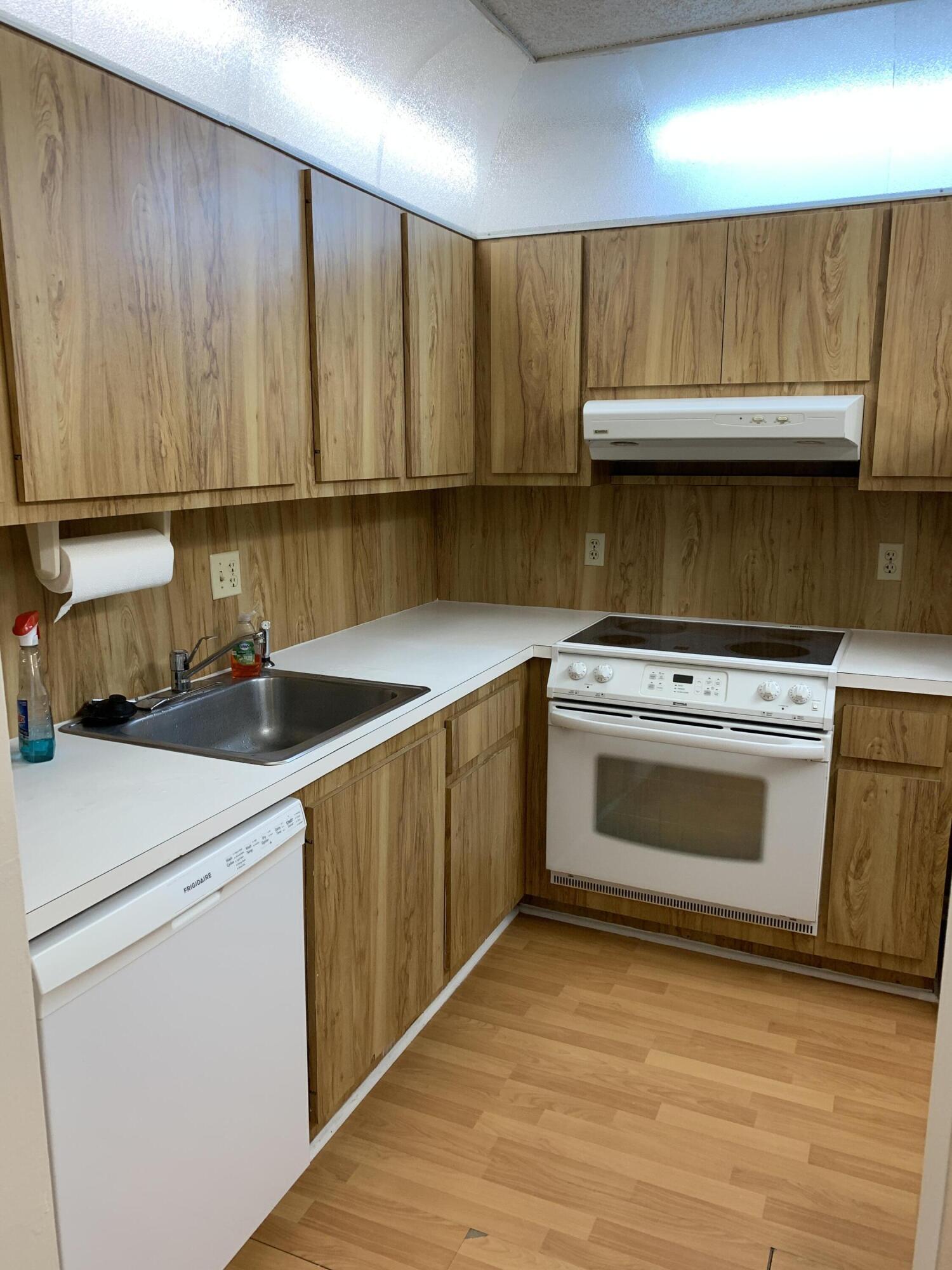 9273 Southwest 8th Street, Unit 416 Boca Raton, FL 33428 - Photo 7 of 14 a kitchen with a sink cabinets and a wooden floor