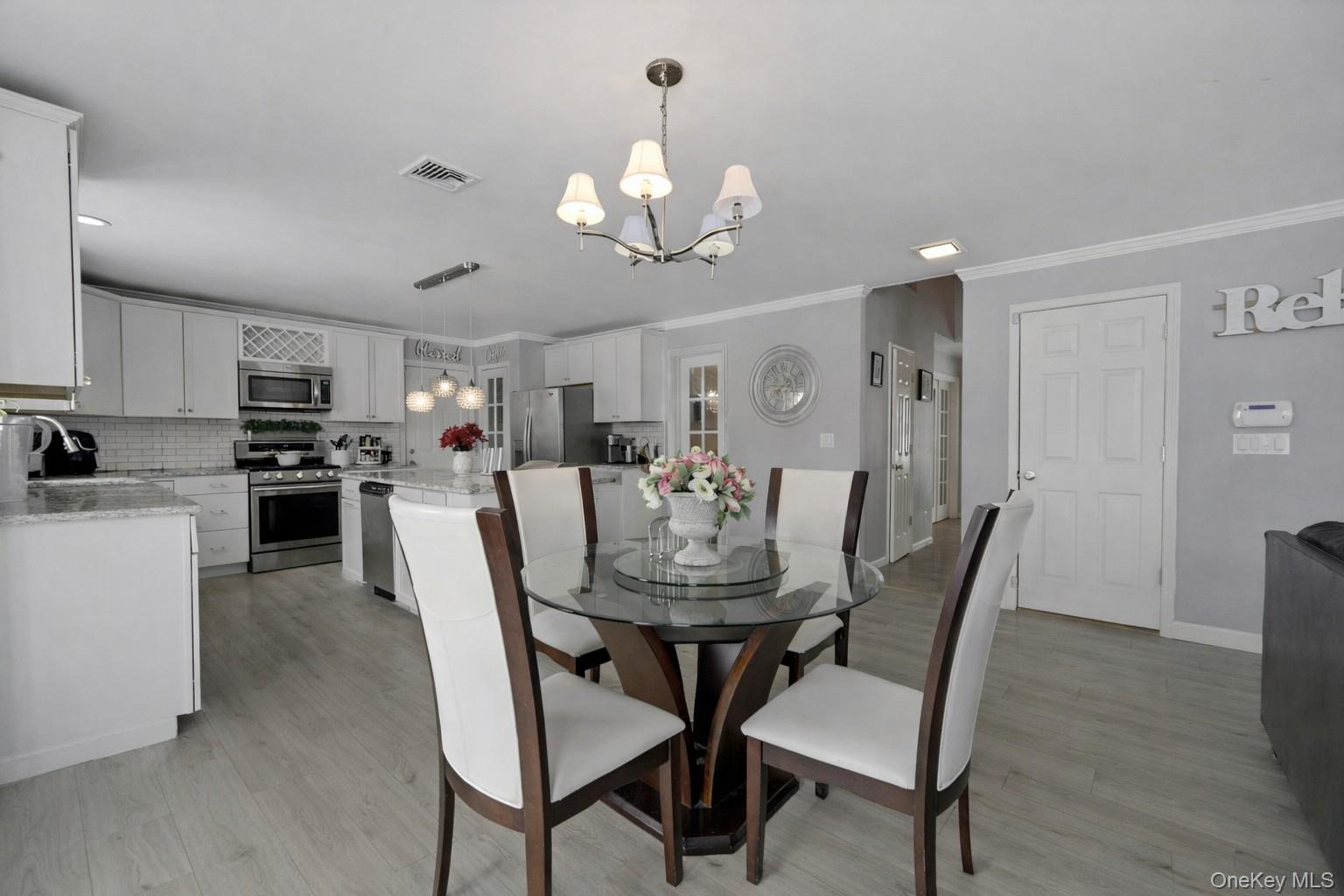 7 Angela's Way Goshen, NY 10924 - Photo 11 of 45 Dining space with suspended lighting, light wood-type flooring, and ornamental molding