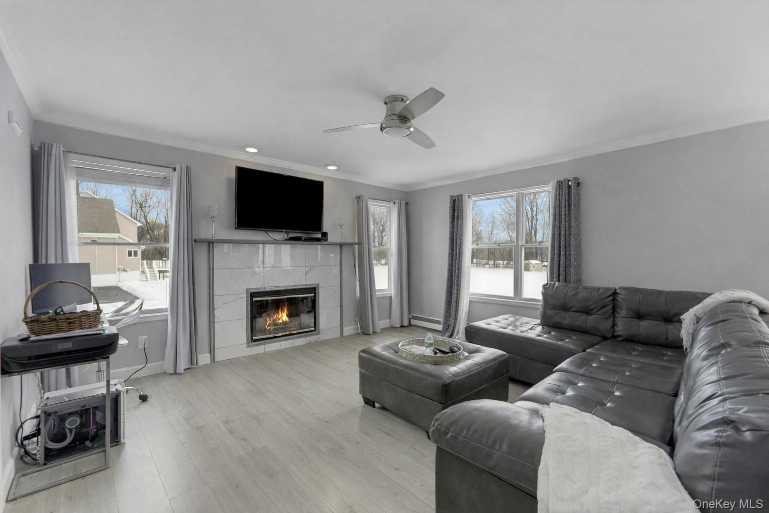 7 Angela's Way Goshen, NY 10924 - Photo 14 of 45 Living area featuring a ceiling fan, crown molding, wood finished floors, a tile fireplace, and recessed lighting
