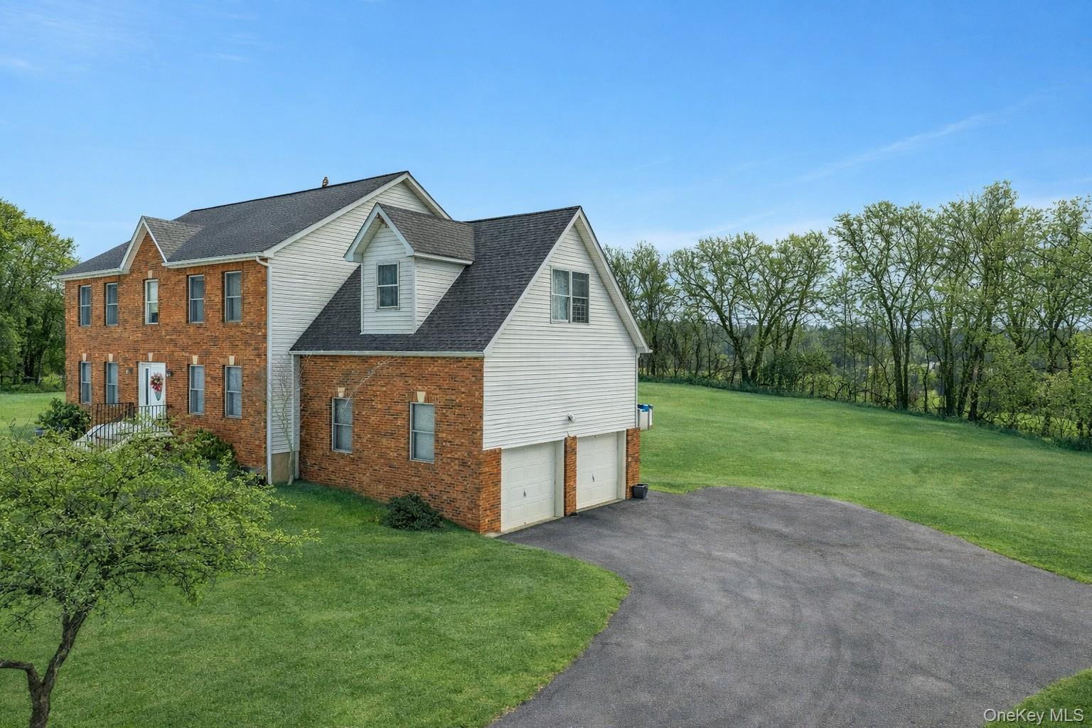 7 Angela's Way Goshen, NY 10924 - Photo 2 of 45 View of side of property with an attached garage, brick siding, a lawn, driveway, and roof with shingles