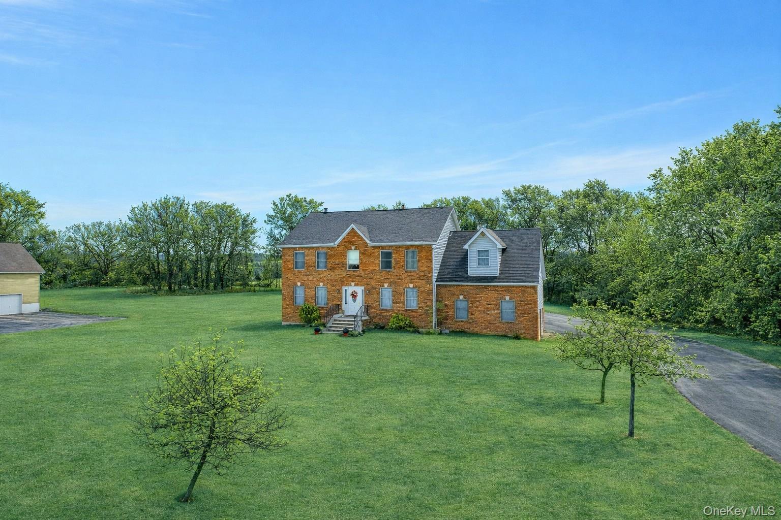 7 Angela's Way Goshen, NY 10924 - Photo 36 of 45 Colonial-style house with a front lawn, brick siding, and view of wooded area