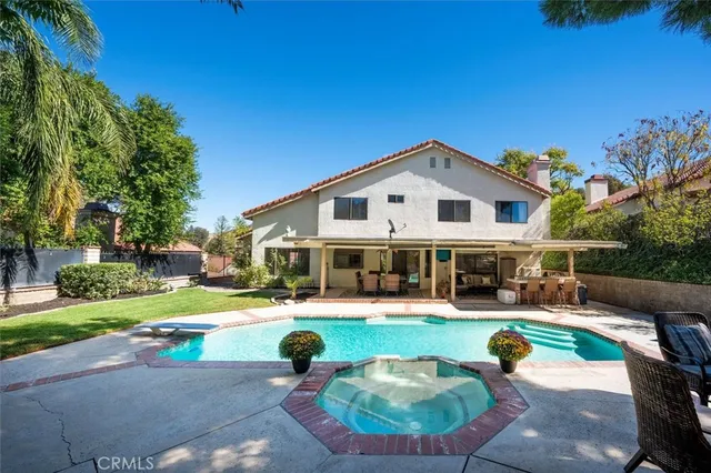 a view of a house with swimming pool and sitting area