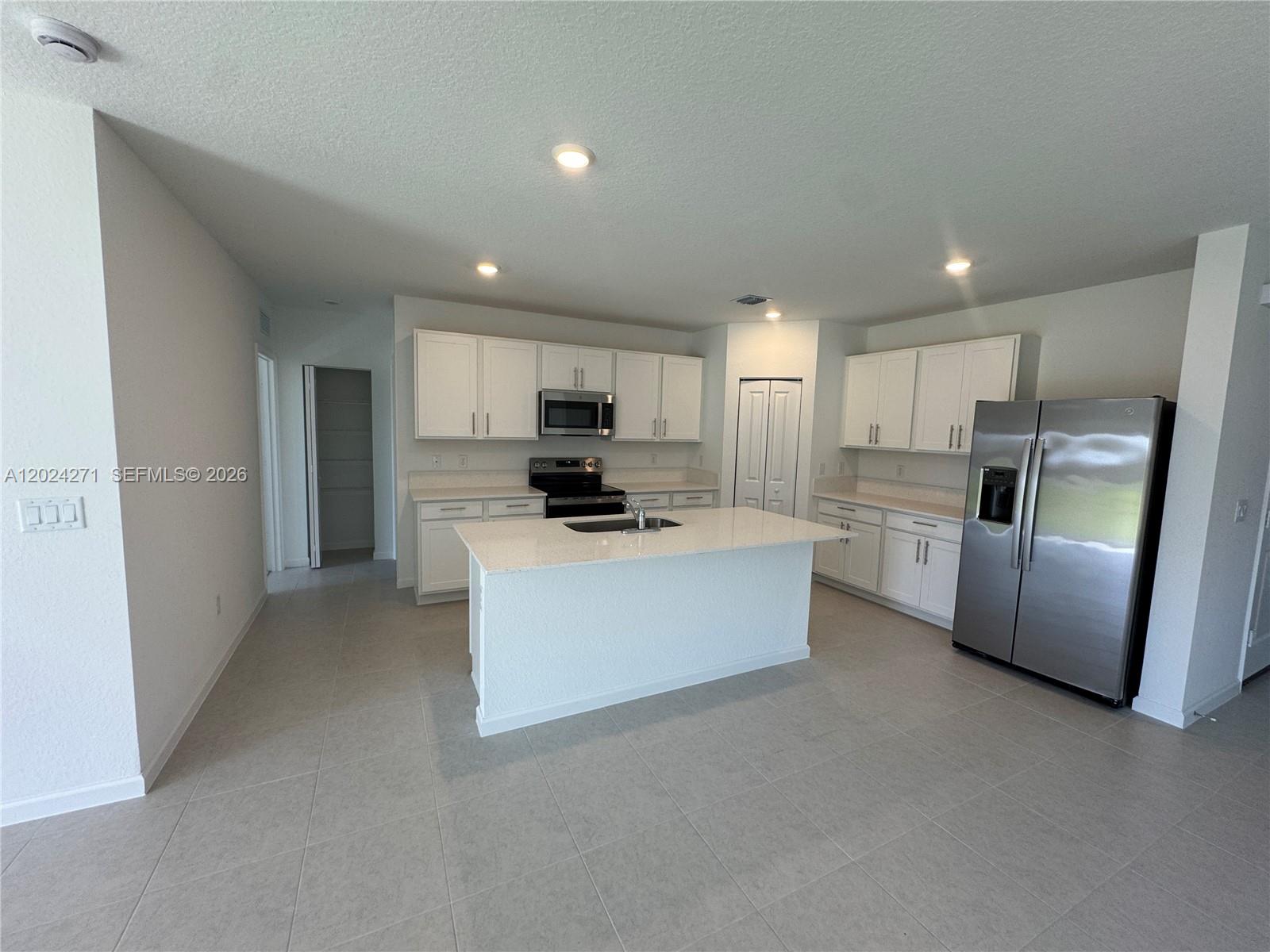 693 Carlyle Way Fort Pierce, FL 34947 - Photo 2 of 19 a kitchen with refrigerator and cabinets