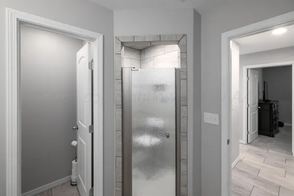 a bathroom with a glass shower door and mirror