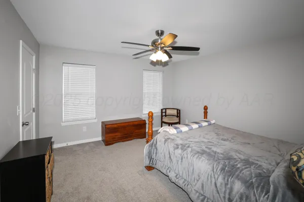 a bedroom with furniture and a ceiling fan