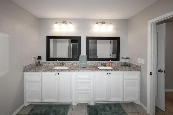 a bathroom with double sink and a mirror