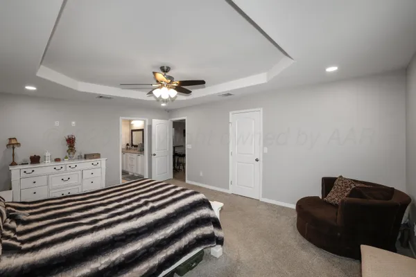 a spacious bedroom with a bed and ceiling fan