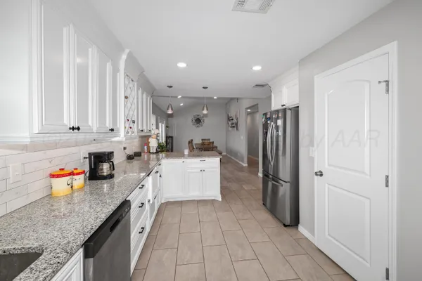 a kitchen with stainless steel appliances granite countertop a refrigerator and a sink