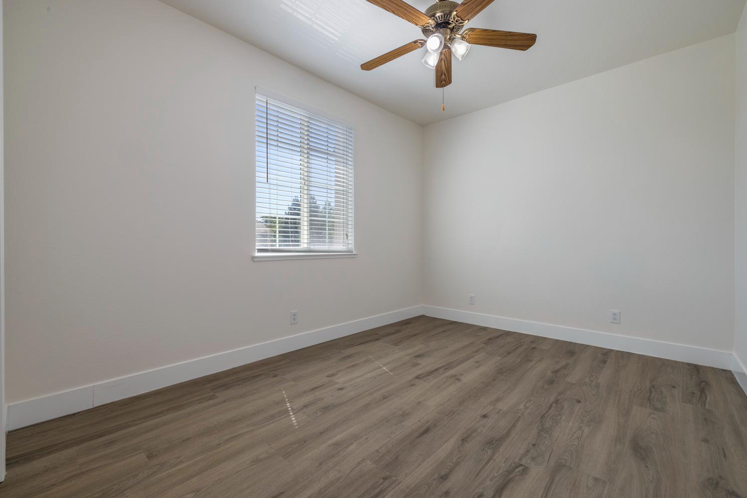 3105 Ripple Court Modesto, CA 95355 - Photo 37 of 46 an empty room with wooden floor fan and windows