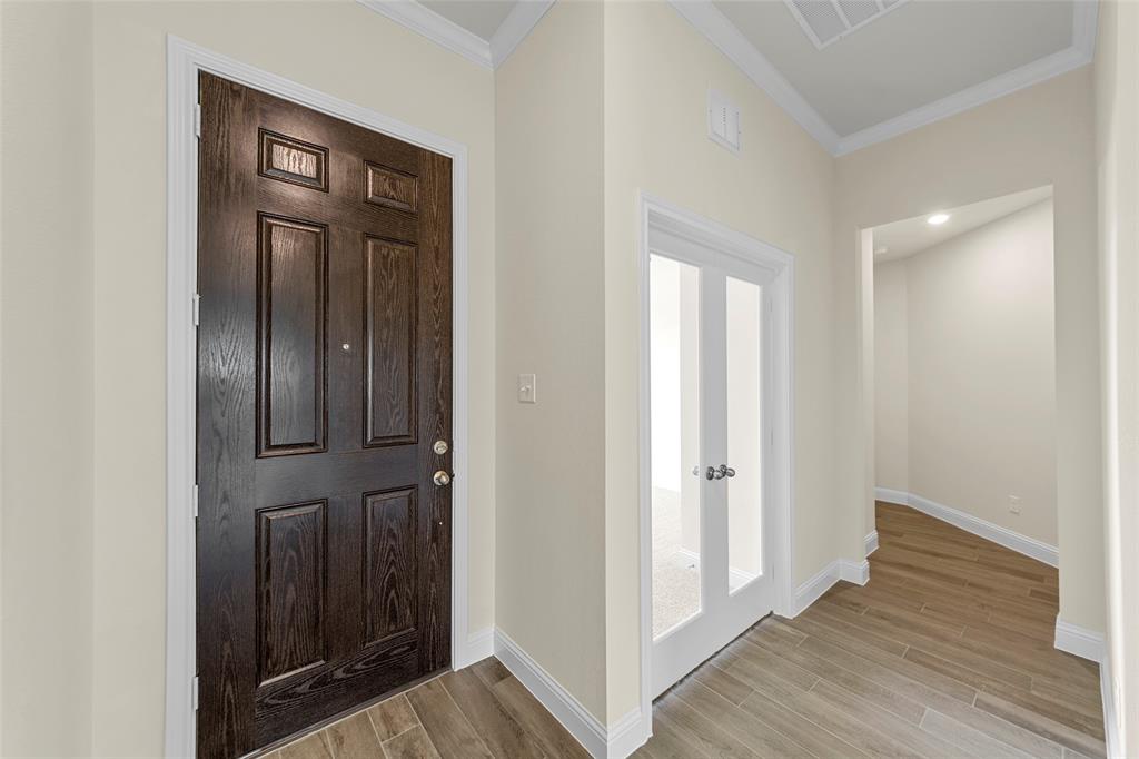 1508 Addison Lane Lancaster, TX 75134 - Photo 17 of 20 Entry foyer featuring wood-finish flooring, a paneled front door, white baseboards, and crown molding
