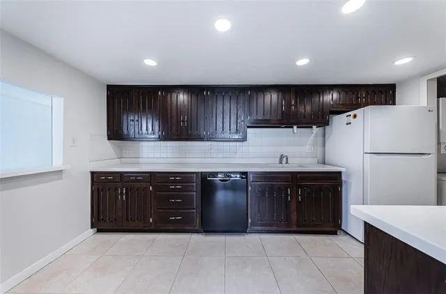 a kitchen with a sink a refrigerator and cabinets