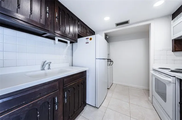 a kitchen with a sink cabinets and a stove top oven