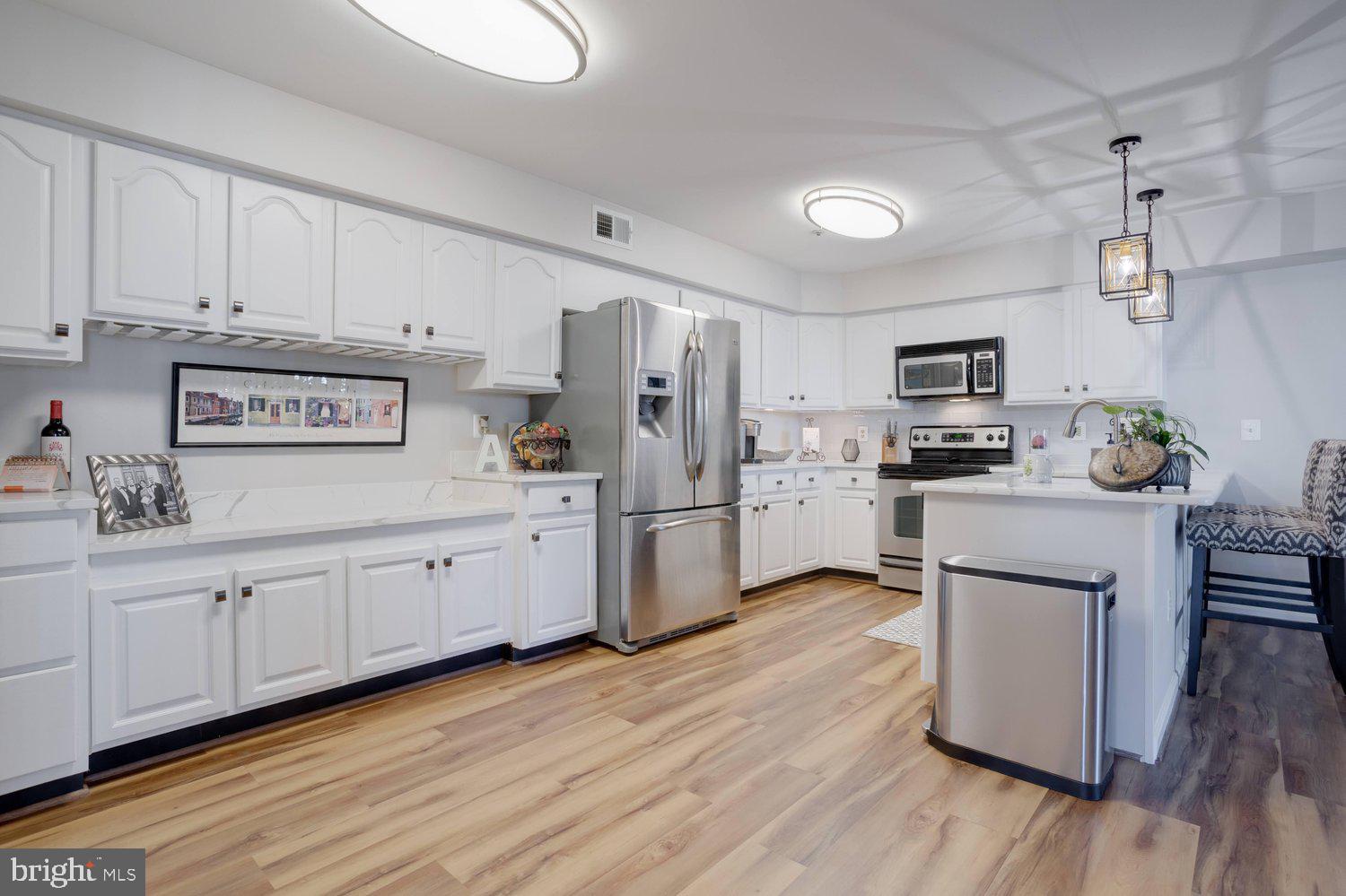 403 Fortress Way, Unit 403 Occoquan, VA 22125 - Photo 13 of 66 a kitchen with stainless steel appliances a refrigerator sink and microwave