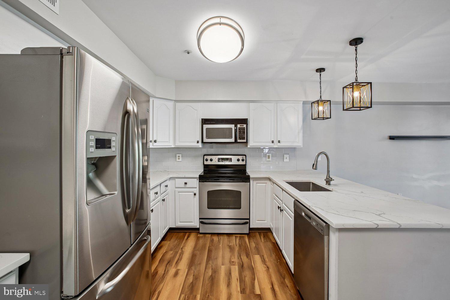403 Fortress Way, Unit 403 Occoquan, VA 22125 - Photo 29 of 66 a kitchen with stainless steel appliances granite countertop a refrigerator a stove and a sink